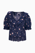 Navy floral cotton blouse with V-neckline, short puff sleeves, and lace-trim hem.
