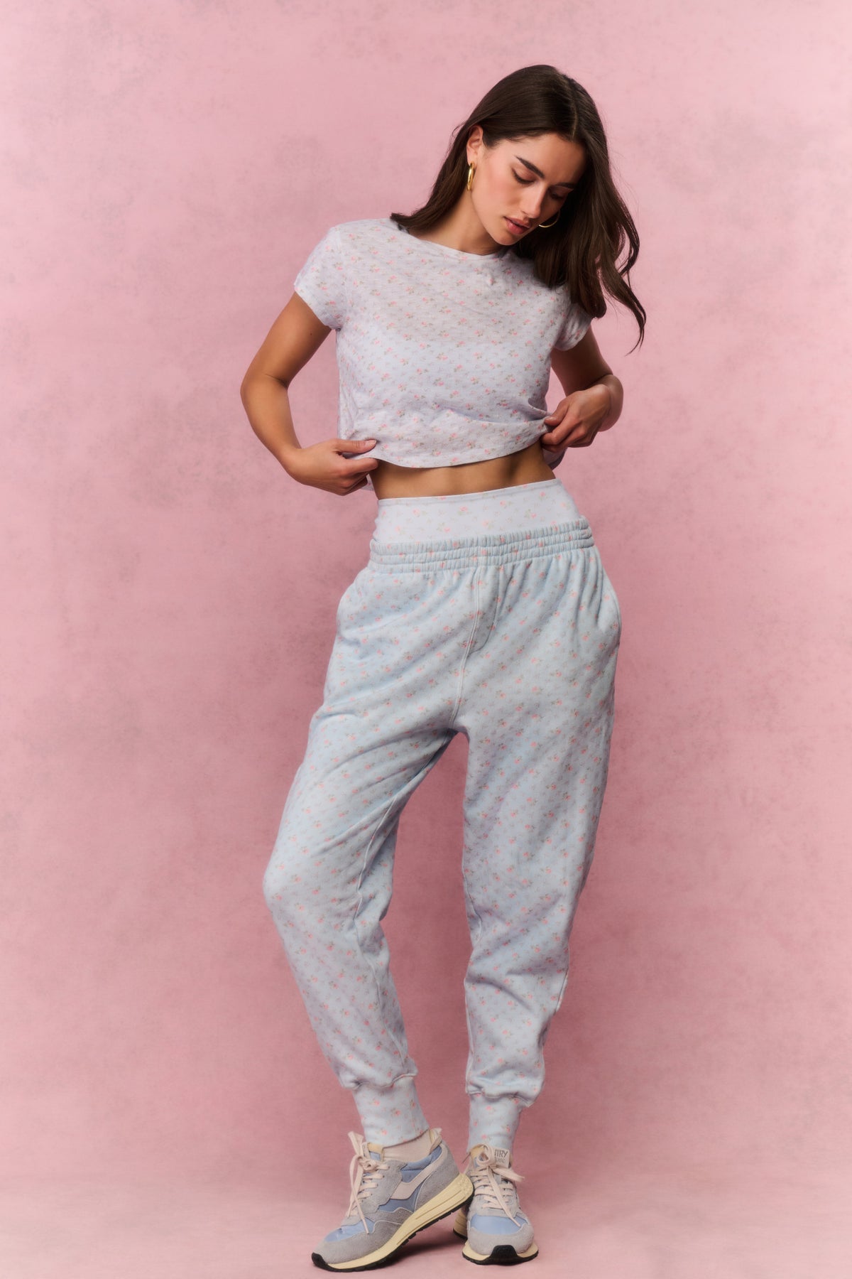 Light blue printed cotton sweatpants on model, side view with elastic cuffs and tapered legs