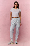 Light blue printed cotton sweatpants on model, front view with elastic cuffs and tapered legs