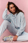 Light blue cotton hoodie with hood and drawstring, seated pose, front kangaroo pocket