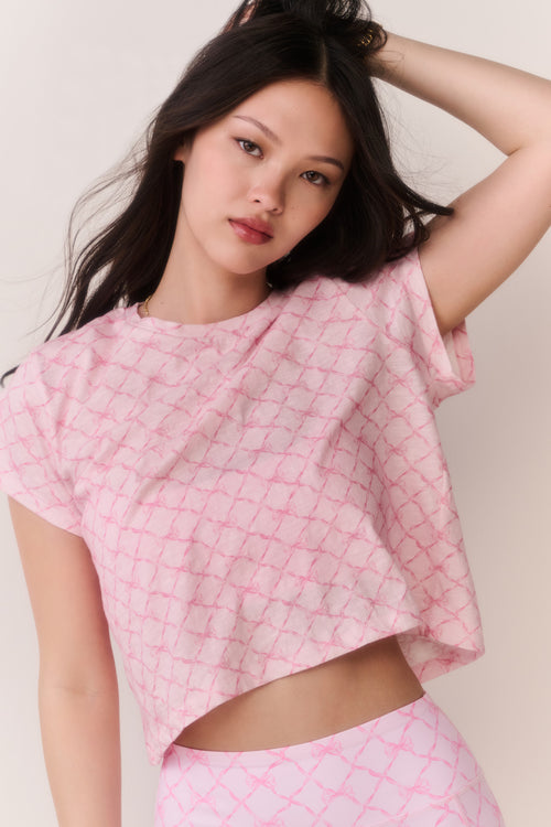 Pink cropped tee with lattice texture, short sleeves and high neckline detail