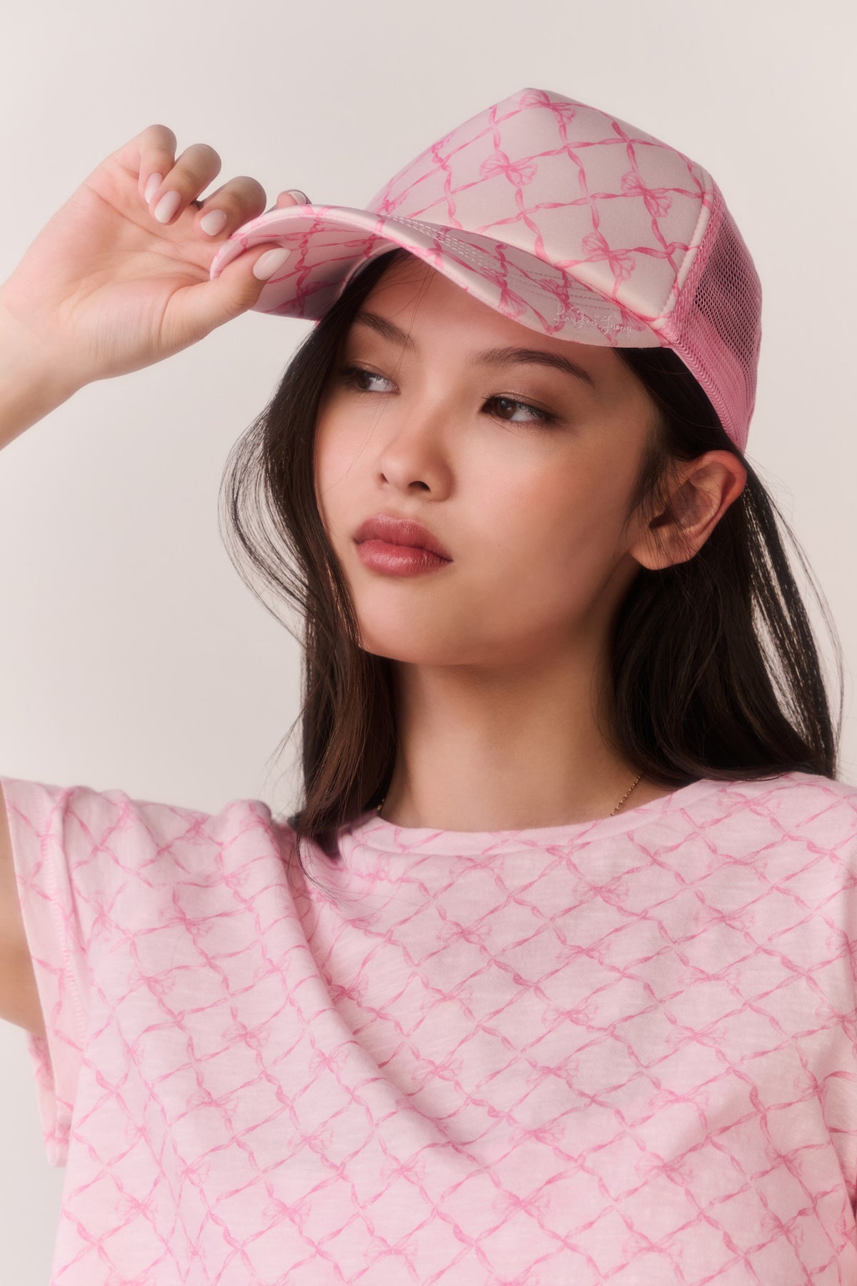 Pink patterned trucker hat with curved brim and mesh back
