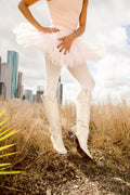 Bone cowboy boots with embossed stitching, pointed toe, and low stacked heel