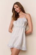 Light blue mini slip dress with lace applique neckline, tied waist, and scalloped hem