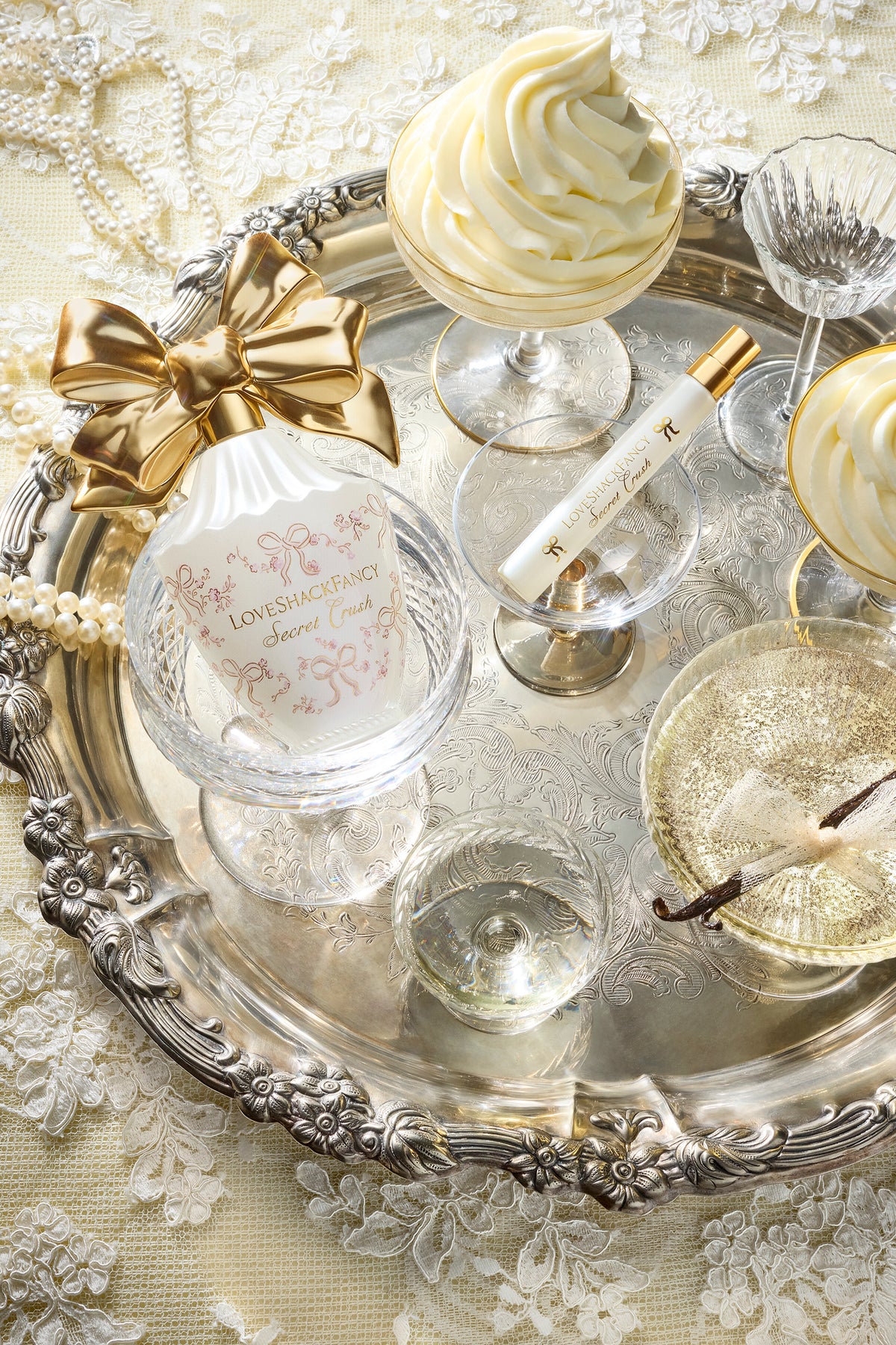 Eau de parfum bottle on an ornate tray with gold bow and glass accents