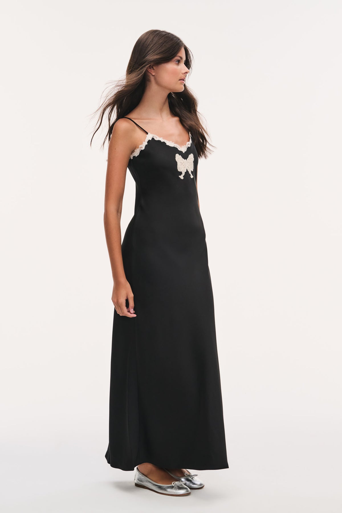 Black maxi dress with lace scalloped neckline, thin straps, and bow applique detail