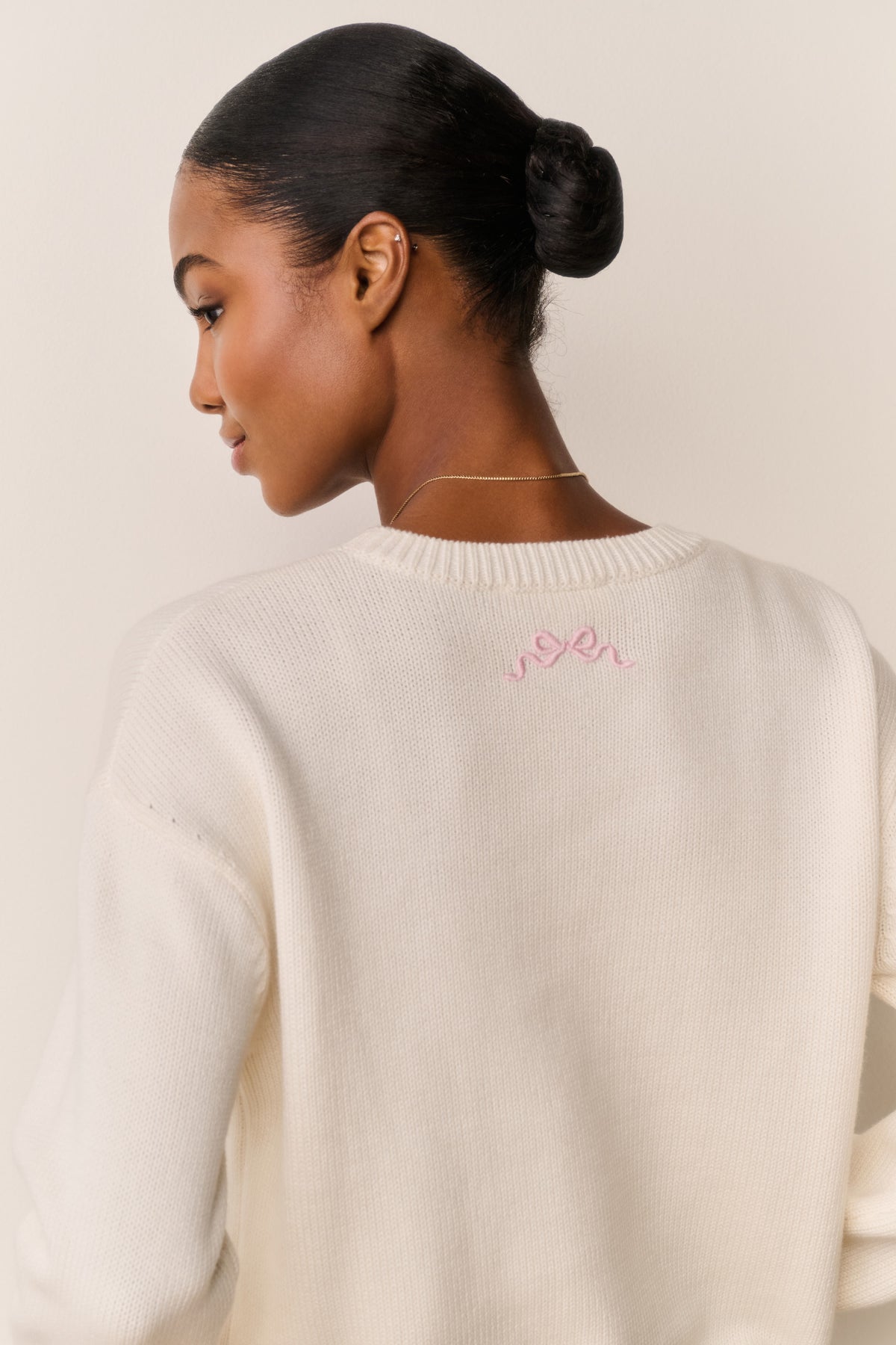 Cream cotton pullover with ribbed crew neck and pink embroidered back logo