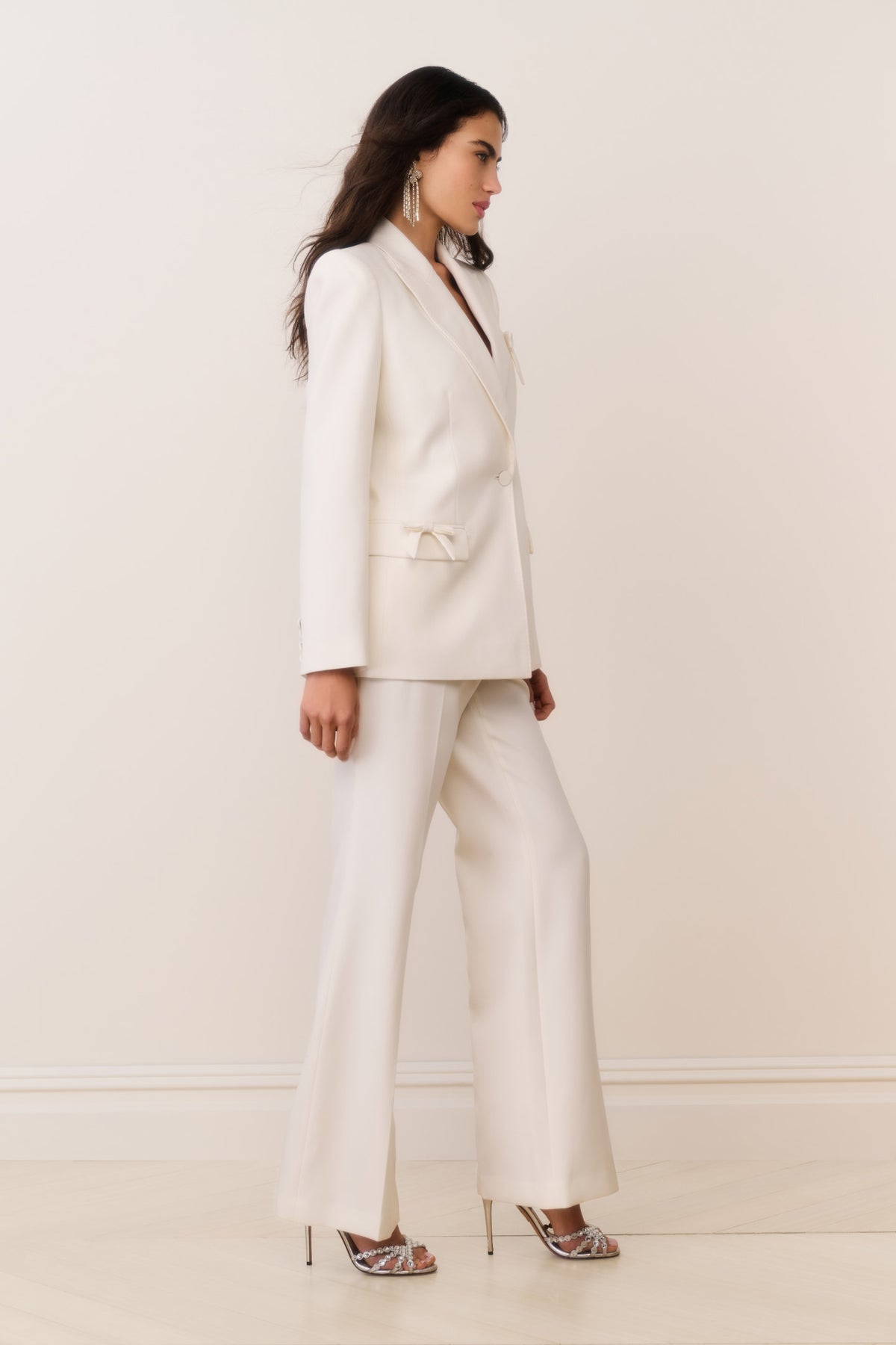 Cream wool-blend blazer with bow-embellished flap pockets and satin bow accents, side view