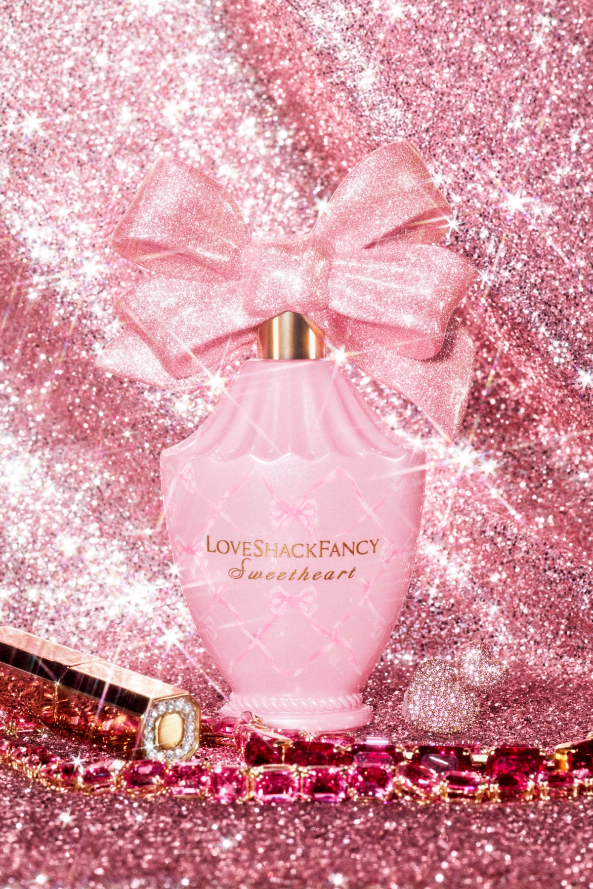 Pink heart-shaped Eau de Parfum bottle with glitter bow and gold cap