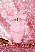 Close-up of pink glitter bow with hair and body perfume mist bottle centerpiece