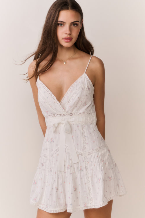 White floral embroidered cotton mini dress with spaghetti straps, V-neck, and tiered skirt