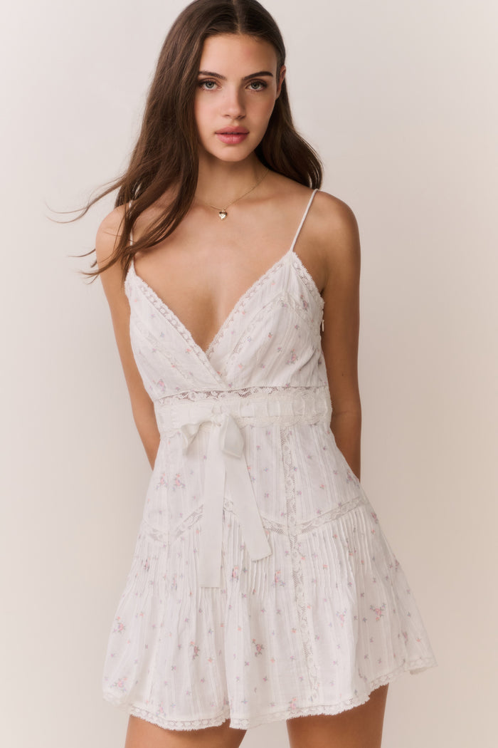 White floral embroidered cotton mini dress with spaghetti straps, V-neck, and tiered skirt
