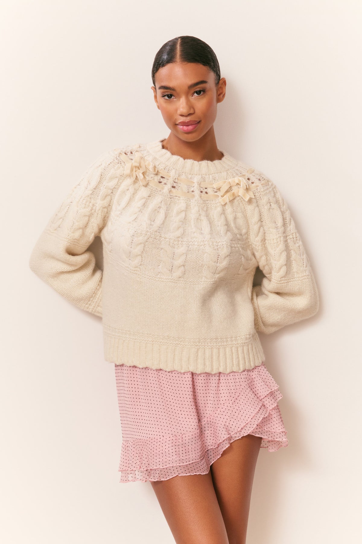 Ivory knit cotton pullover with textured cable pattern and ruffled collar