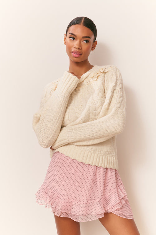 Ivory knit cotton pullover with ruffled neckline and long ribbed cuffs, cropped