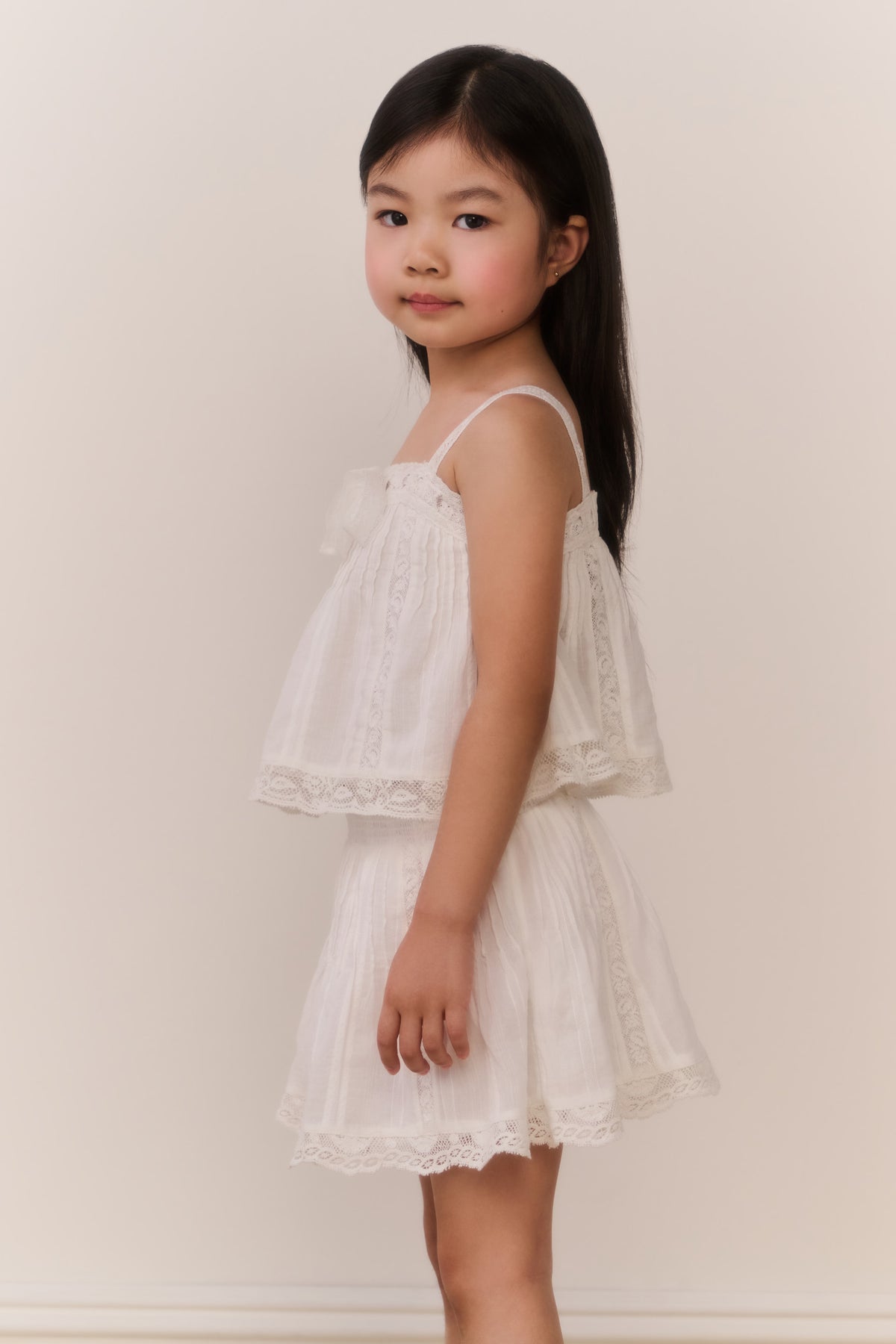 Girls' white cotton sleeveless top with lace trim and pleated ruffles