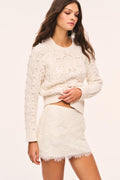 Off-white knit lace mini skirt with textured floral pattern and scalloped hem