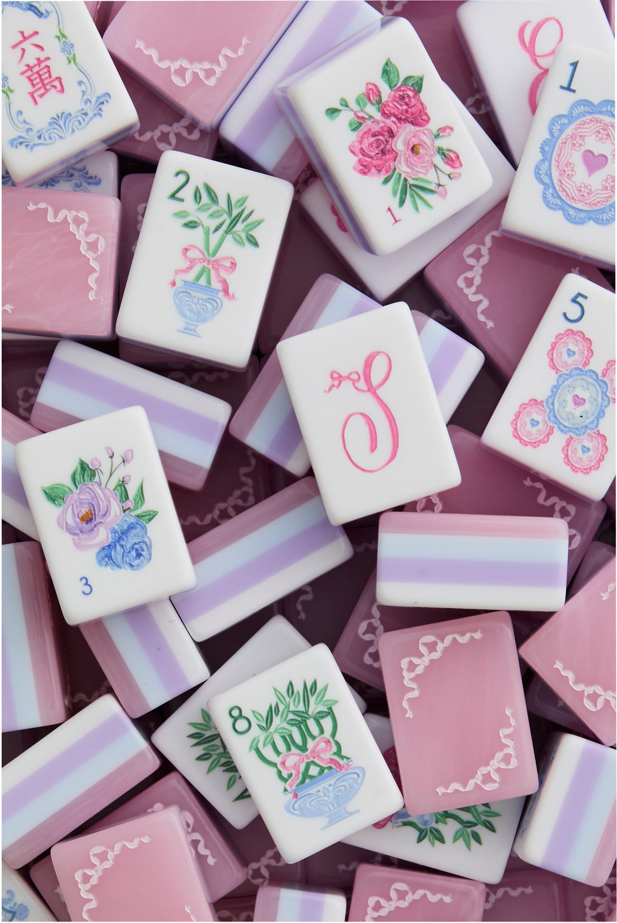 Close-up of pastel mahjong tiles with floral motifs and decorative borders