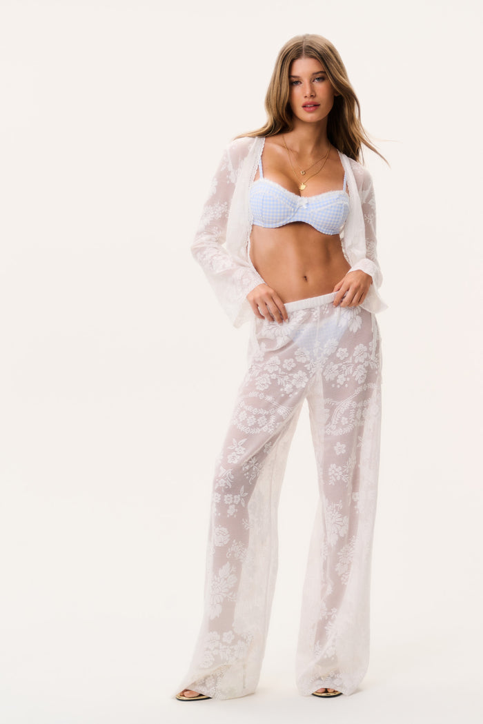 White sheer lace cover-up pants with wide legs and allover floral motifs, full view