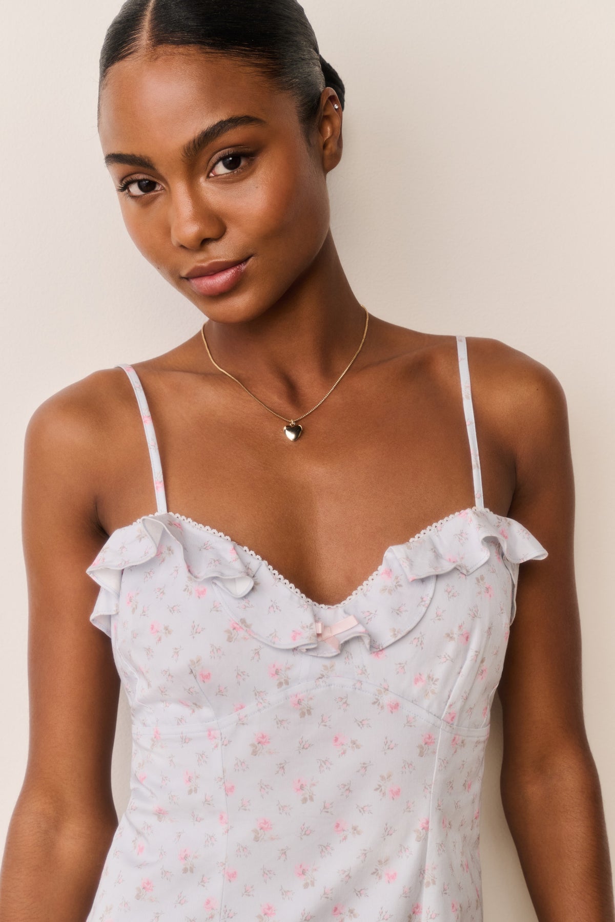 Front view detail of floral cotton mini dress with ruffled bust and thin straps