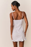 Back view of floral cotton mini dress with thin straps and short ruffle hem
