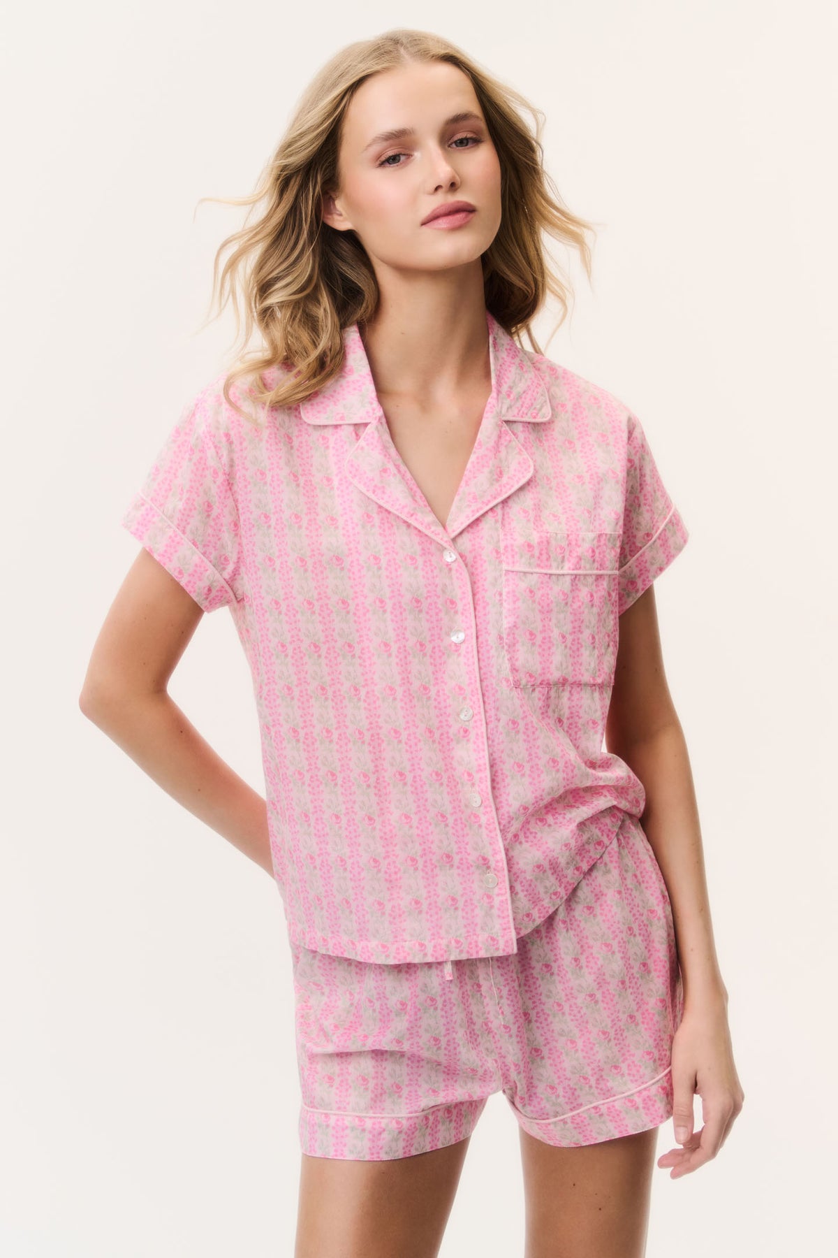 Pink cotton pajama set with short-sleeve button-up top and layered hem matching shorts