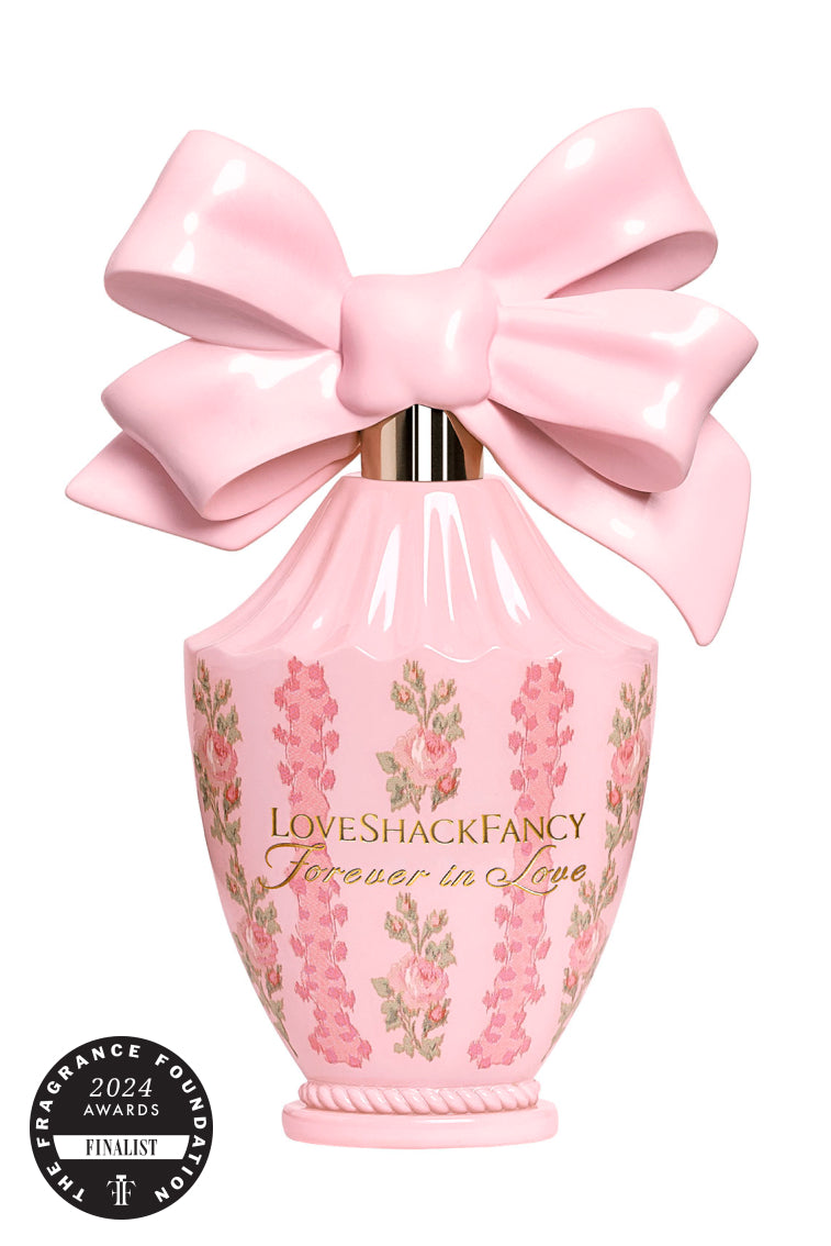 Pink eau de parfum bottle with oversized satin bow and floral label