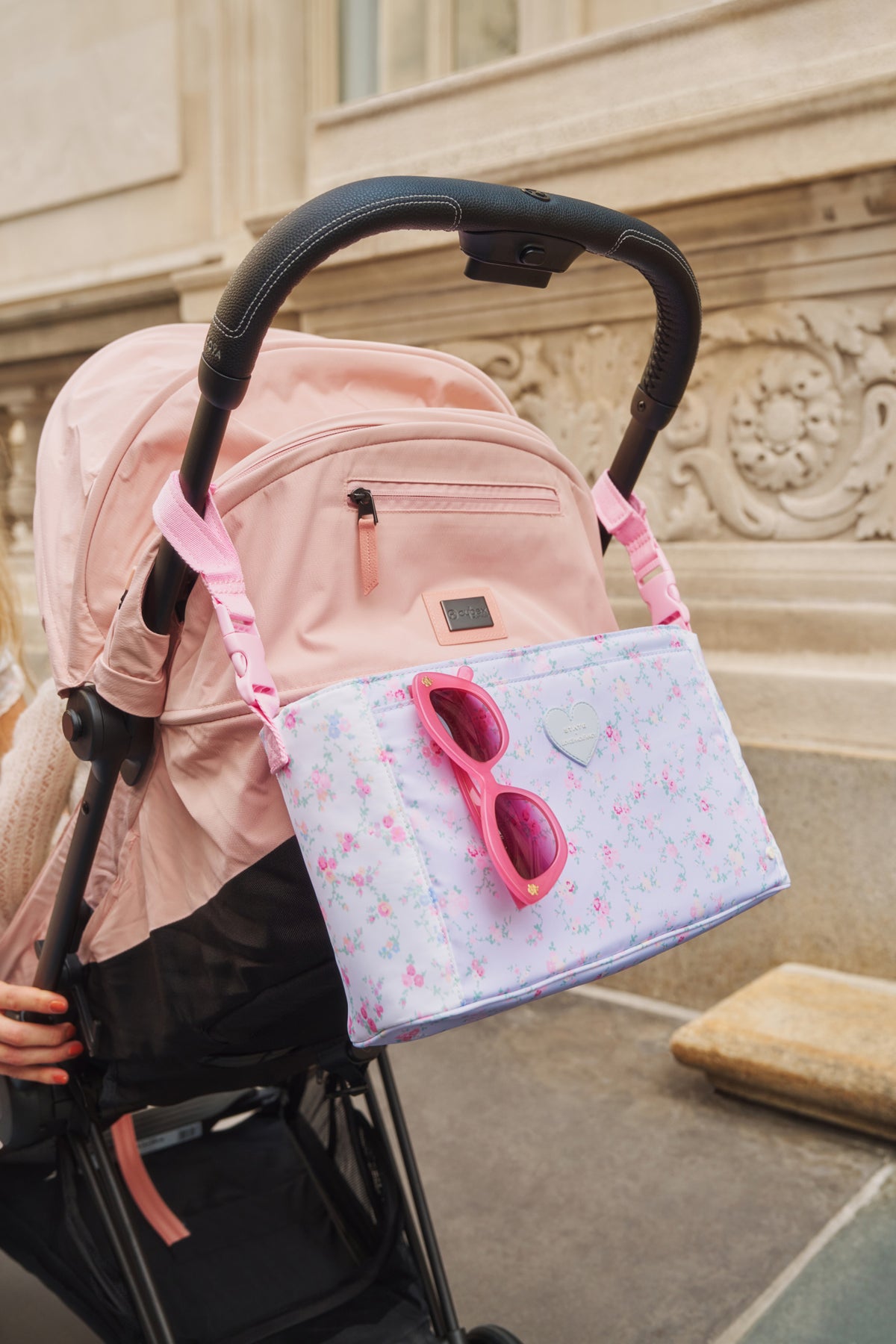 Floral stroller organizer bag with pink handles and front zipper pocket