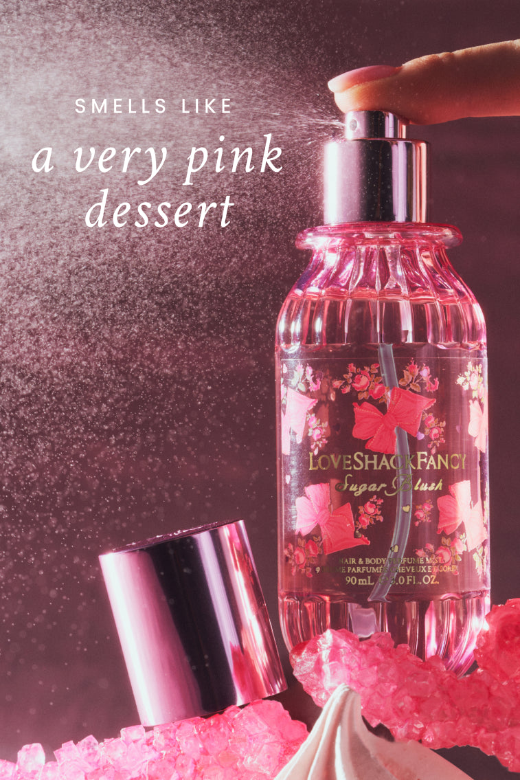 Pink hair and body perfume mist bottle with metallic silver cap, side view