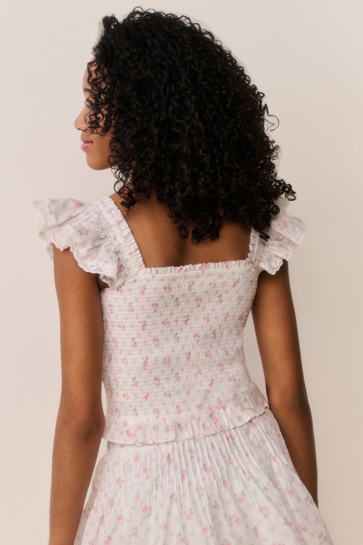 Floral cotton top back view with ruffled cap sleeves and gathered peplum tiers