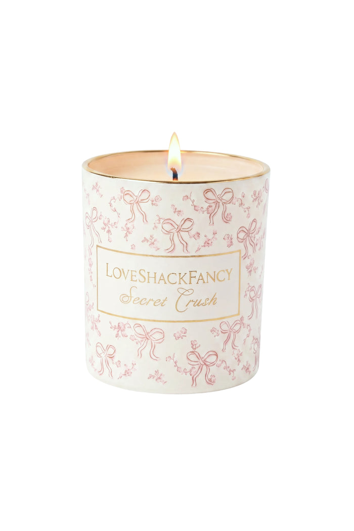 Scented candle in white glass with pink bow pattern and “Secret Crush” label