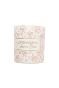 Scented candle in white jar with pink bow pattern and “Secret Crush” label