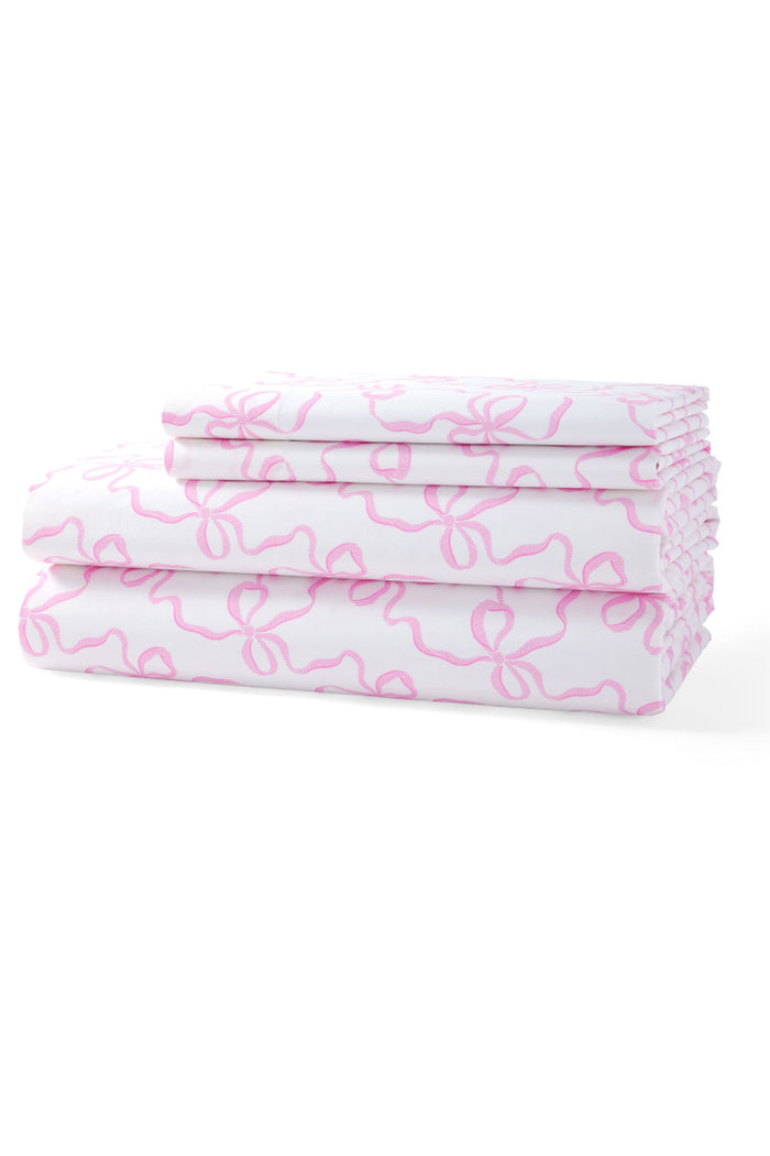 Printed cotton sheet set with pink bow pattern, neatly folded