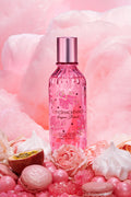 Pink hair and body perfume mist bottle with metallic silver cap, floral label