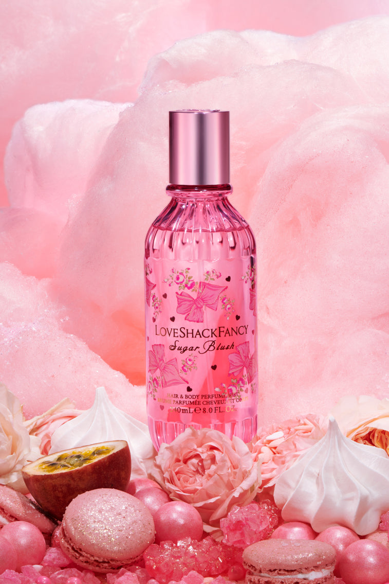 Pink hair and body perfume mist bottle with metallic silver cap, floral label