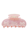 Pink translucent pixie claw clip with bow-like ribbon accents