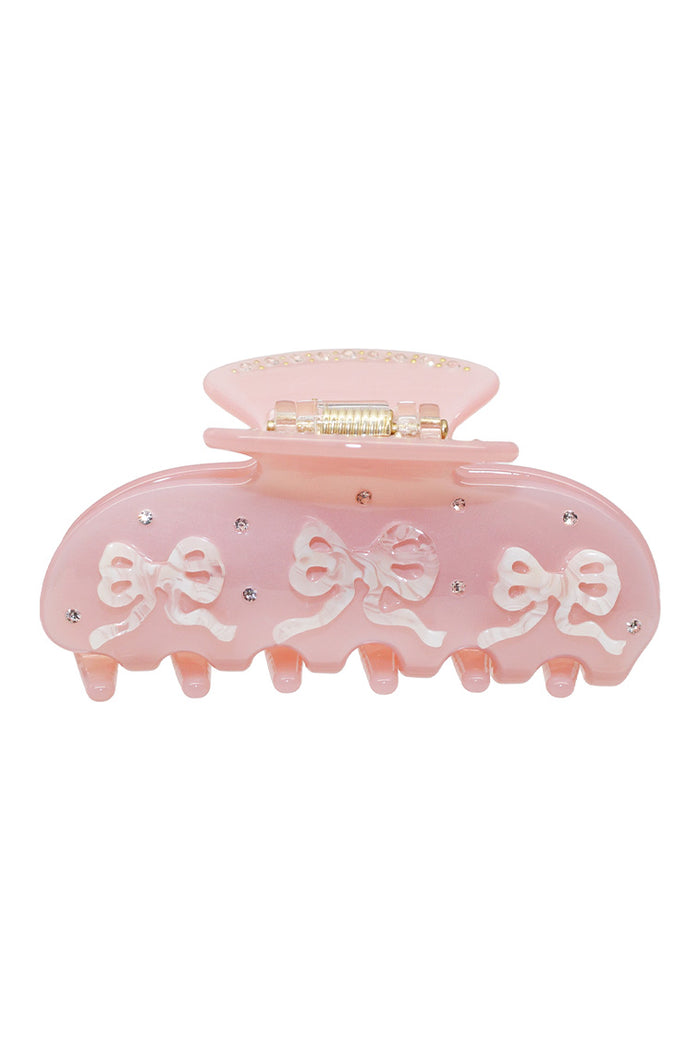 Pink translucent pixie claw clip with bow-like ribbon accents