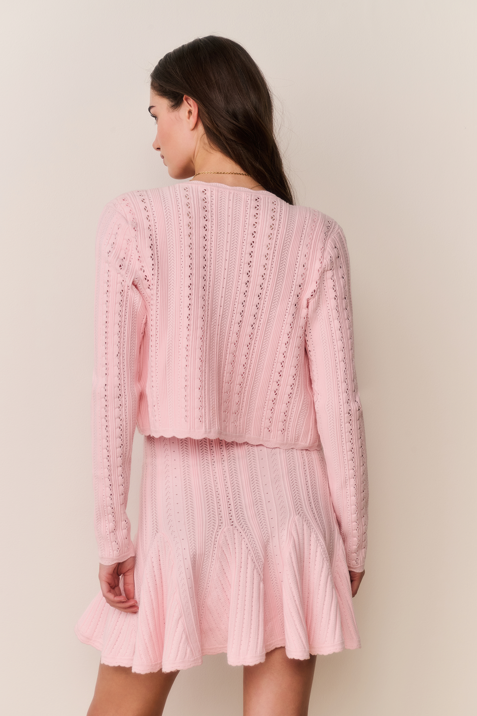 Pink pointelle stretch cardigan, back view with long sleeves and button closure