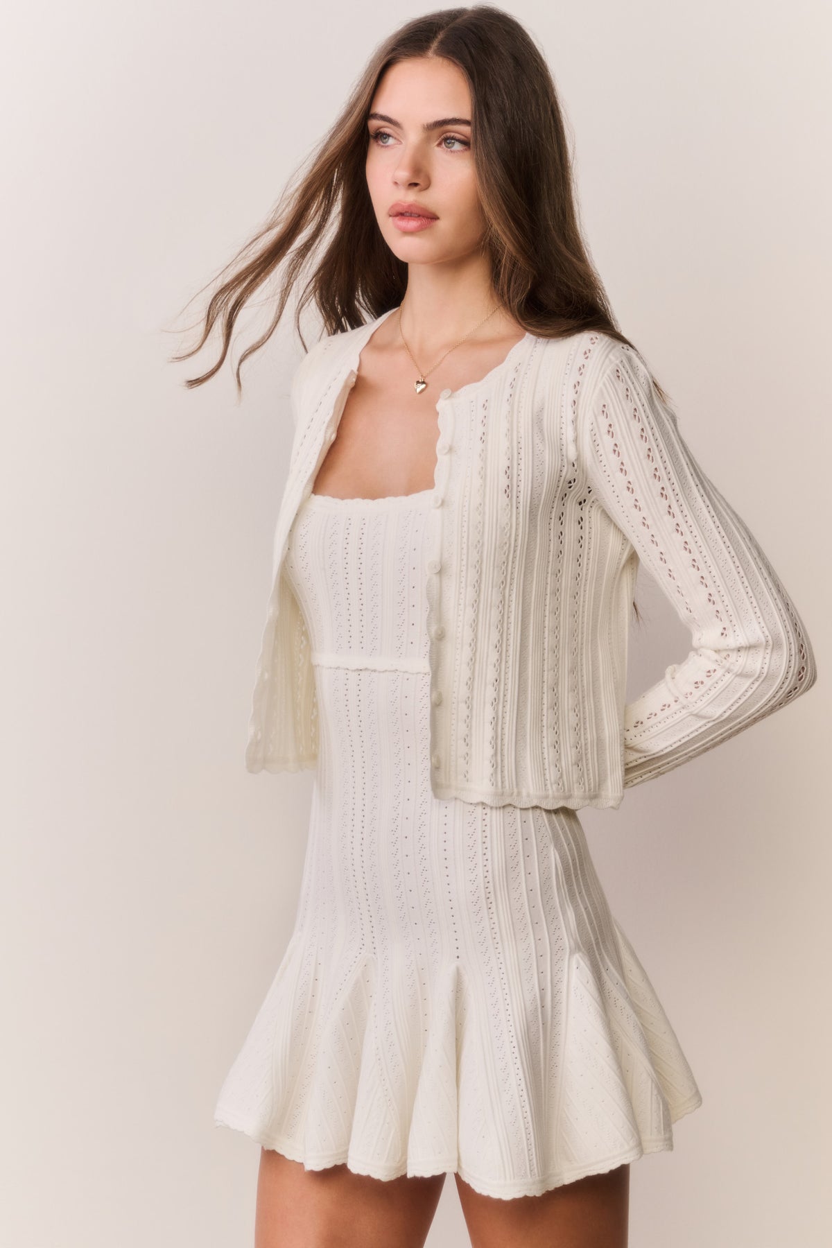 White pointelle stretch cardigan with open front, long sleeves, scalloped trim