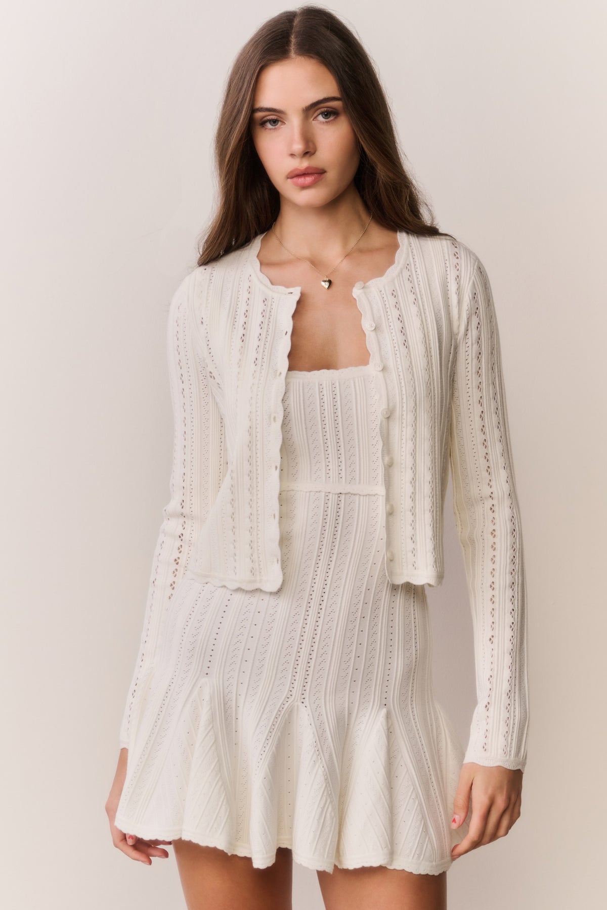 White pointelle stretch cardigan with open front, long sleeves, textured vertical panel