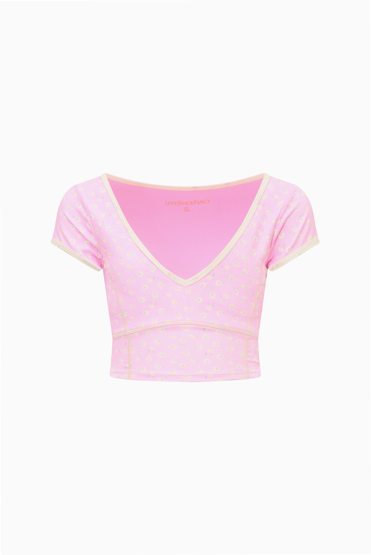 Light pink tween active top with V-neck, short sleeves, and small patterned print