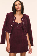 Bordeaux tweed jacket with long sleeves, open neckline, and flap pockets with decorative buttons