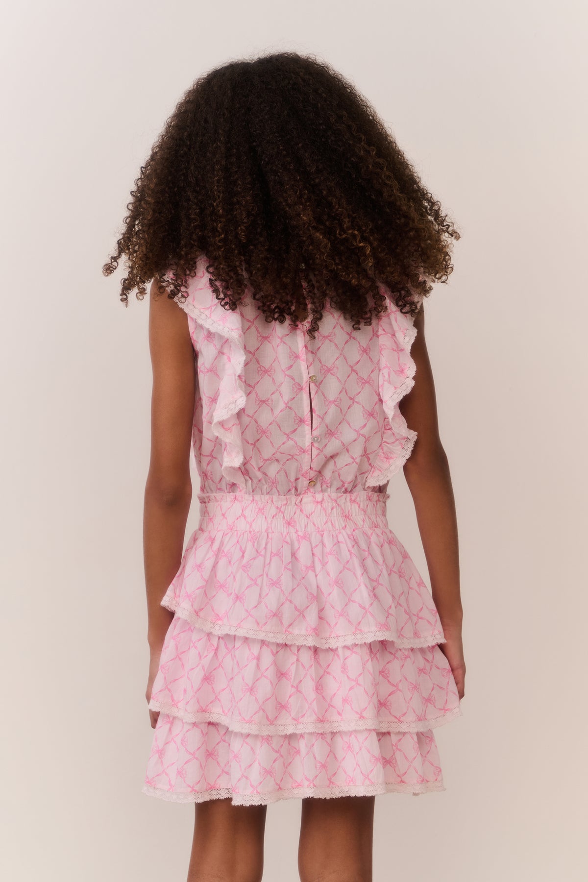 Pink lattice tiered dress with cap sleeves and ruffle hem (back view)