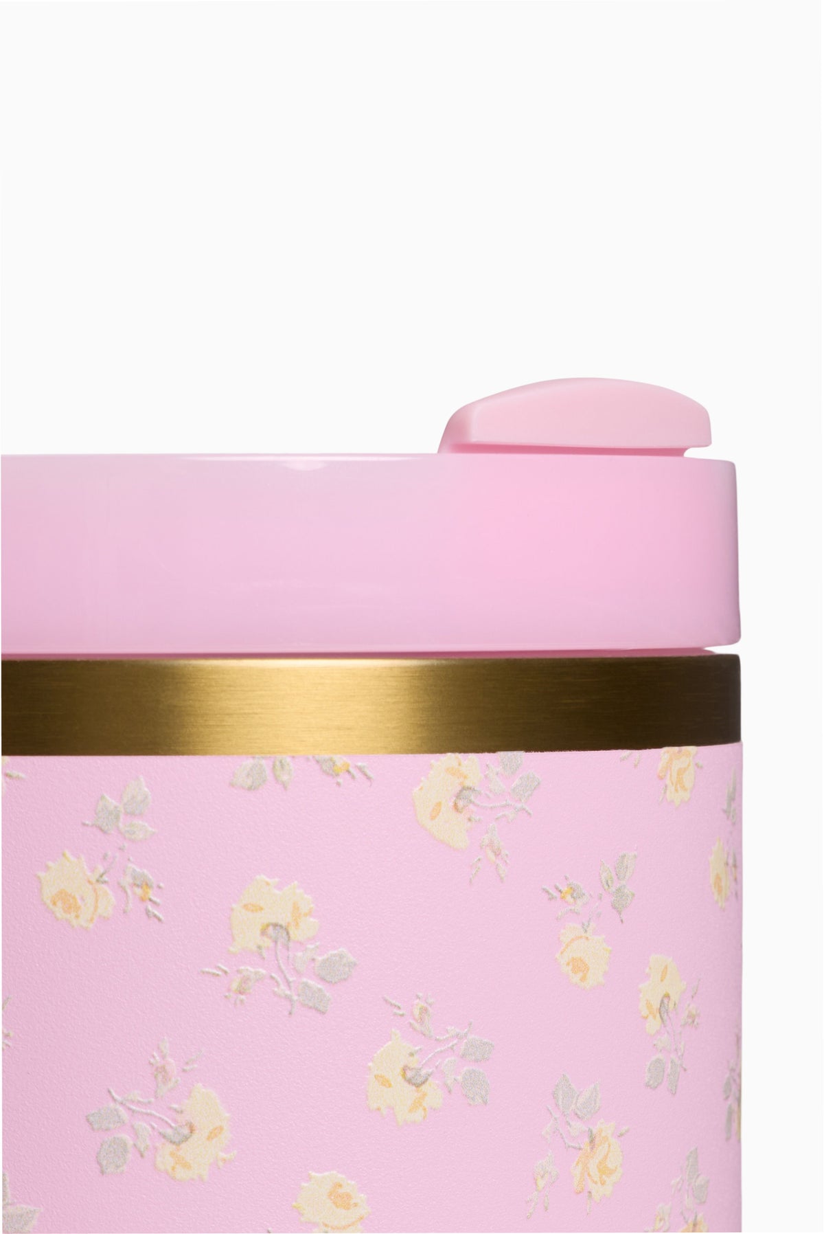 Pink tumbler top with gold band and gold floral print, close-up view