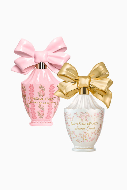 Two decorative perfume jars in pink and white with large satin bows