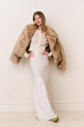 Faux fur jacket in burnt caramel, open-front with long sleeves and shaggy texture.