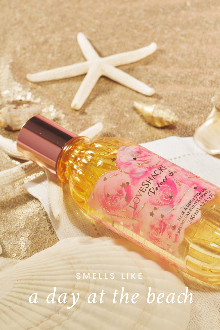 Hair and body perfume mist bottle on the beach with starfish and seashells