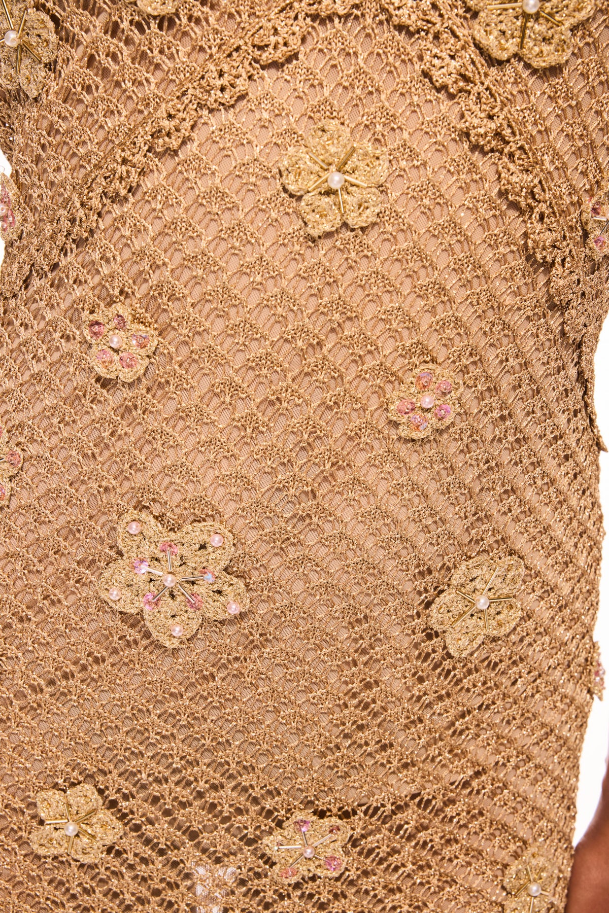Close-up of metallic crochet mesh with floral embellishments and sequins