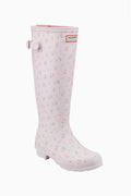 White tall rain boots with small pink floral print, Hunter logo patch and side strap