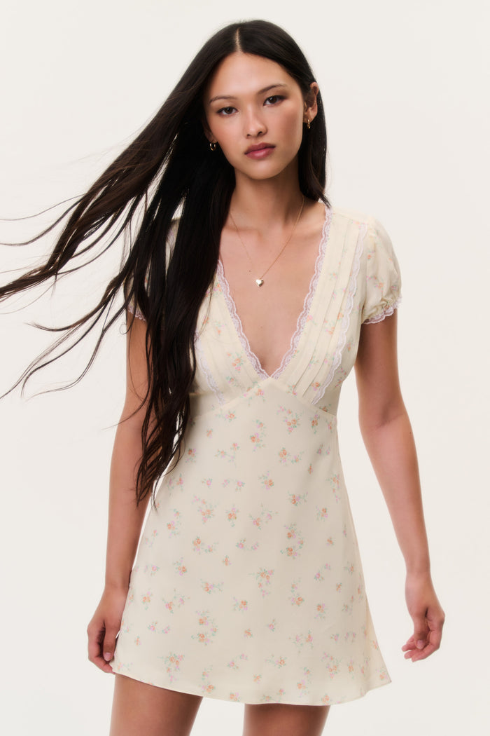 Floral mini dress with lace V-neck and short puff sleeves, light cream background