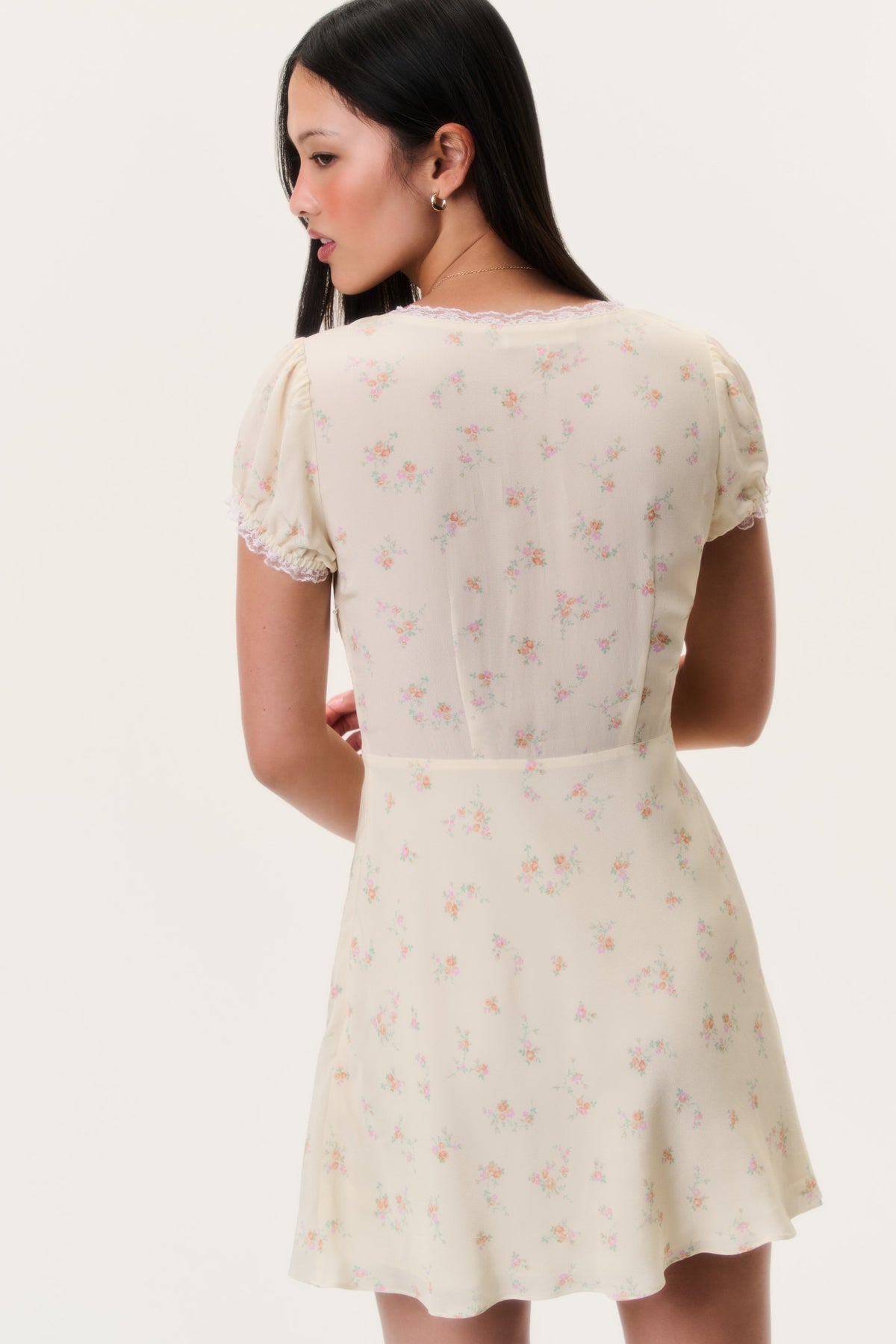 Floral mini dress back view with lace neckline trim and puff sleeves, light cream